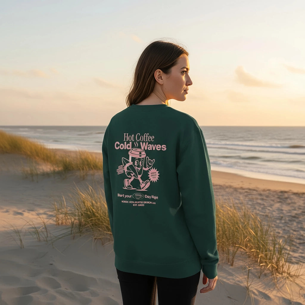 <img src="Hot-Coffee-Cold-Waves-Sweatshirt-glaze-green-back-woman-beach-horizon_1024px.webp" alt="Frau in den Dünen mit Blick zum Horizont, trägt das Hot Coffee Cold Waves Sweatshirt in Glaze Green: großer Backprint mit maritimen Motiven, natürliche Strandatmosphäre, gefertigt aus 100% GOTS-zertifizierter Bio-Baumwolle">