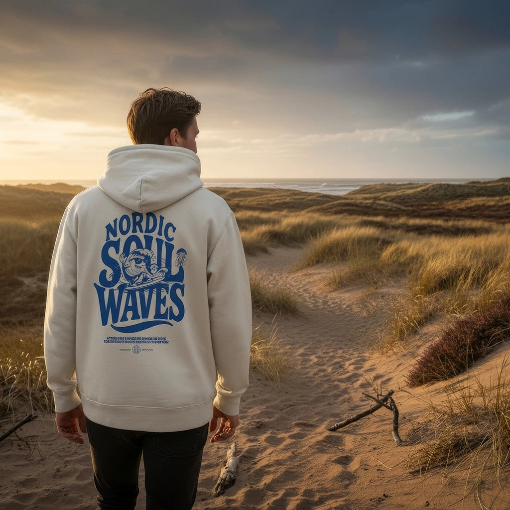 <img src="tide-chaser-hoodie-off-white-duenen-meer-rueckansicht.jpg" alt="Mann läuft durch die Dünen auf das Meer zu und trägt den Unisex Tide-Chaser Hoodie in Off-White: Rückansicht mit großem Backprint eines surferischen Wellen-Charakters und dynamischem 'Nordic Soul Waves'-Schriftzug, gefertigt aus 100% GOTS-zertifizierter Bio-Baumwolle, umspielt von natürlichem Küstenlicht">