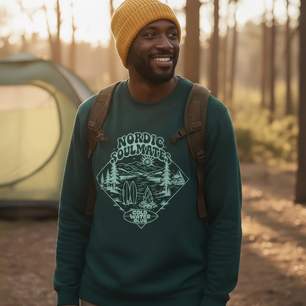 <img src="Cold-Water-Club-Sweatshirt-glaze-green-front-man-tent-forest-outdoor_Original.webp" alt="Zufrieden lächelnder Mann beim Camping im Wald, trägt das Cold Water Club Sweatshirt in Glaze Green: großer Frontprint mit nordischer Landschaft in einer türkisfarbenen Raute (Retro-Print), Outdoor-Atmosphäre mit Rucksack und Zelt im Hintergrund, gefertigt aus 100% GOTS-zertifizierter Bio-Baumwolle">