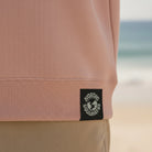 <img src="Hot-Coffee-Cold-Waves-Sweatshirt-cotton-pink-back-Detail-Webetikett_1024px.webp" alt="Detailaufnahme des Webetiketts am Saum des Hot Coffee Cold Waves Sweatshirts in Cotton Pink: GOTS-Zertifizierung, Markenlogo und Pflegehinweise in Nahansicht, Sweatshirt mit orangefarbenem Print, gefertigt aus 100% GOTS-zertifizierter Bio-Baumwolle">