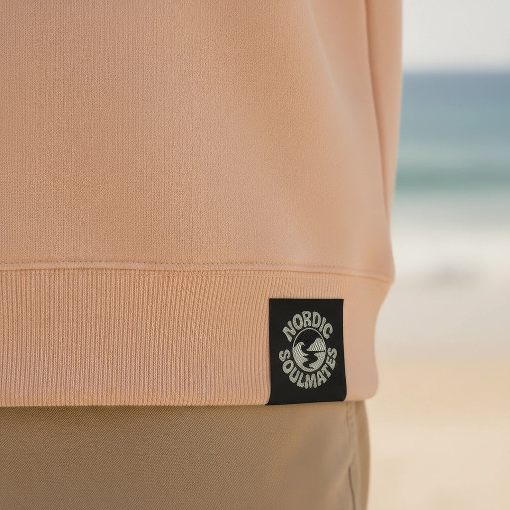 <img src="Hot-Coffee-Cold-Waves-Sweatshirt-fraiche-peche-back-Detail-Webetikett_1024px.webp" alt="Detailaufnahme des Webetiketts am Hot Coffee Cold Waves Sweatshirt in Fraîche Pêche: Nahansicht zeigt GOTS-Zertifizierung, Markenlogo und Pflegehinweise, gefertigt aus 100% GOTS-zertifizierter Bio-Baumwolle">