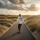 <img src="Ocean-Culture-Club-Sweatshirt-off-white-back-man-carving-Longboard-1024px.webp" alt="Mann carvt auf dem Longboard eine Straße zwischen den Dünen entlang, trägt das Ocean Culture Club Sweatshirt in Off-White: Rückansicht mit großem Backprint (Schriftzug 'Ocean Culture Club' und gradlinige Illustrationen von Wasserpflanzen, Algen und Korallen), entspannte Küstenatmosphäre, gefertigt aus 100% GOTS-zertifizierter Bio-Baumwolle">